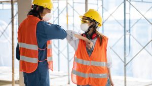 colleagues-with-safety-equipment-touching-elbow